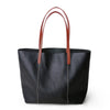 Structured full grain leather tote with laptop compartment, designed for women needing a spacious, professional shoulder bag.

