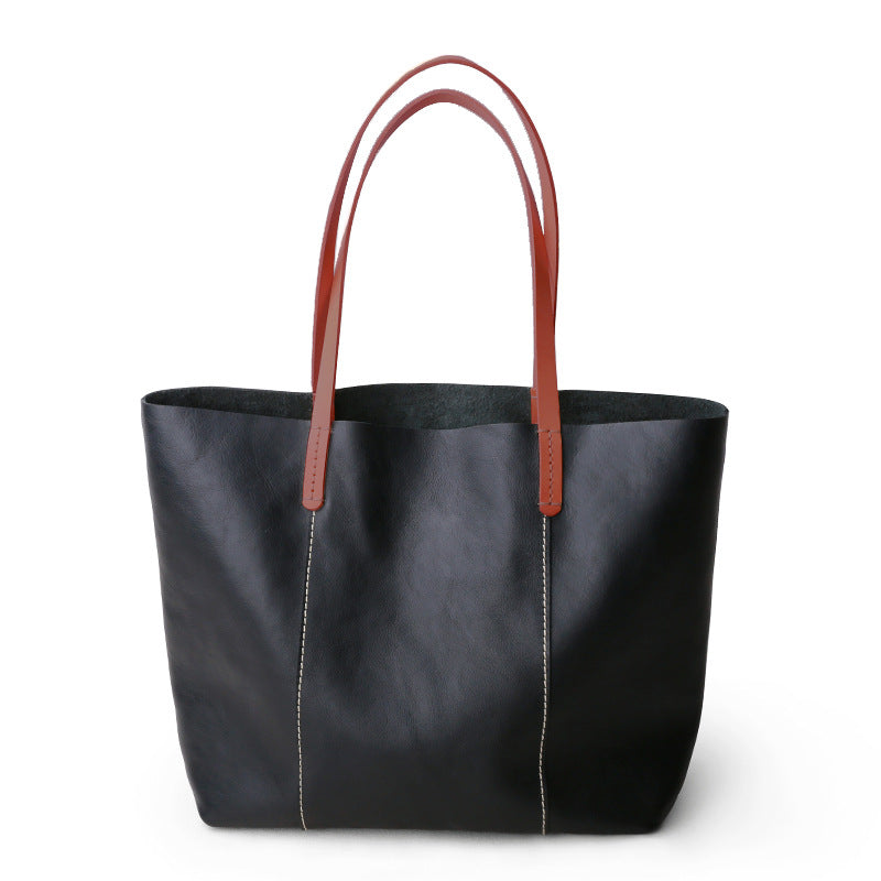 Structured full grain leather tote with laptop compartment, designed for women needing a spacious, professional shoulder bag.

