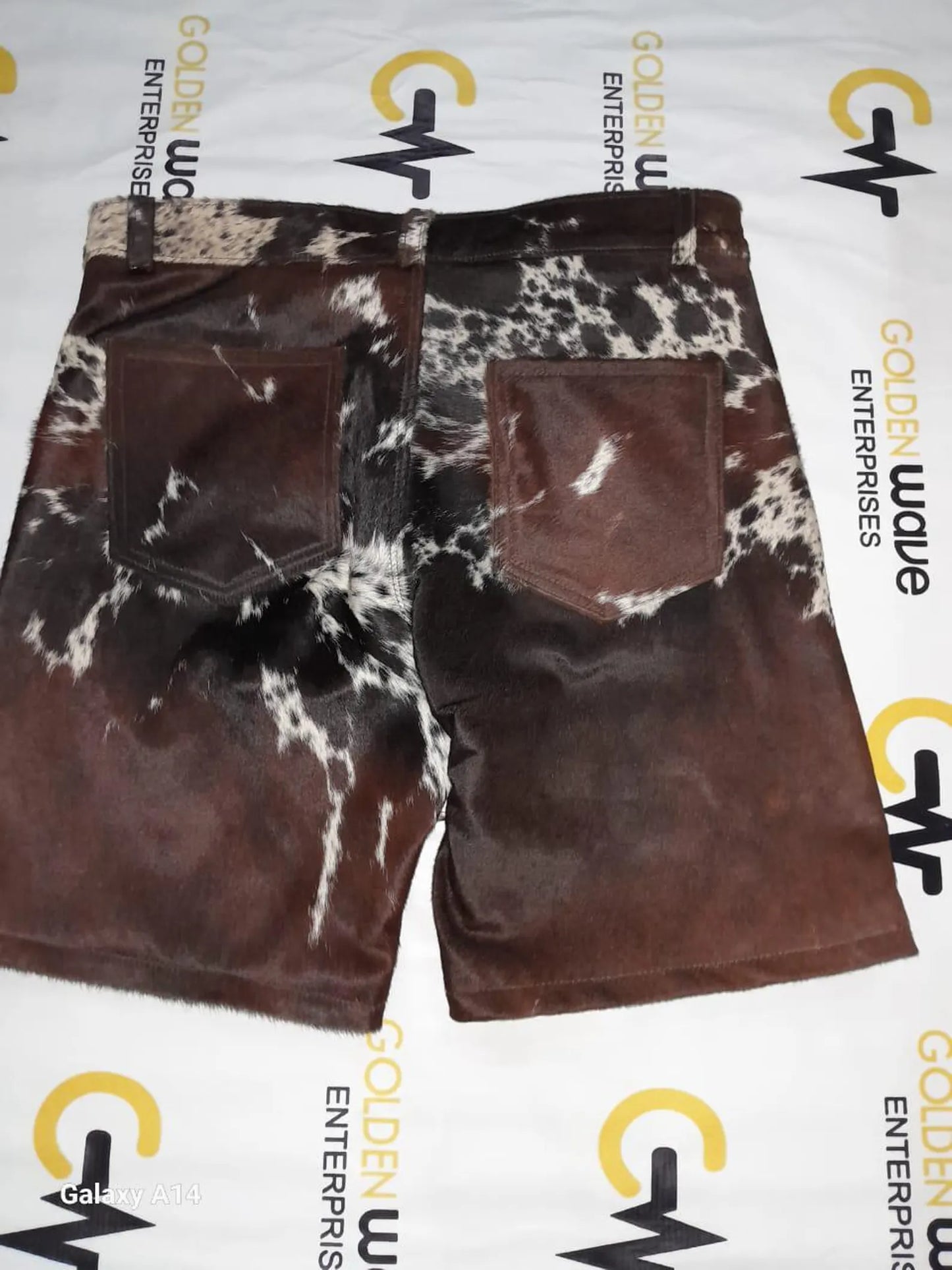 Cow print shorts made from real cowhide for unique western outfits. Tricolor tones for cowboy events, rodeo fashion, and rustic summer wear.
