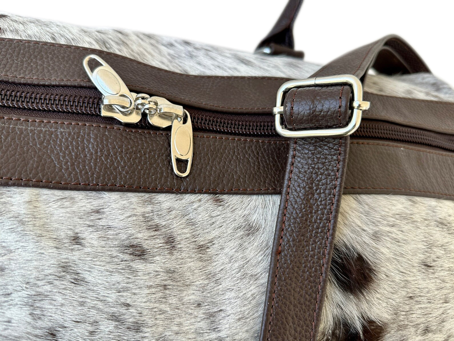 Unwind in elegance with this cowhide duffle bag, your perfect travel companion.