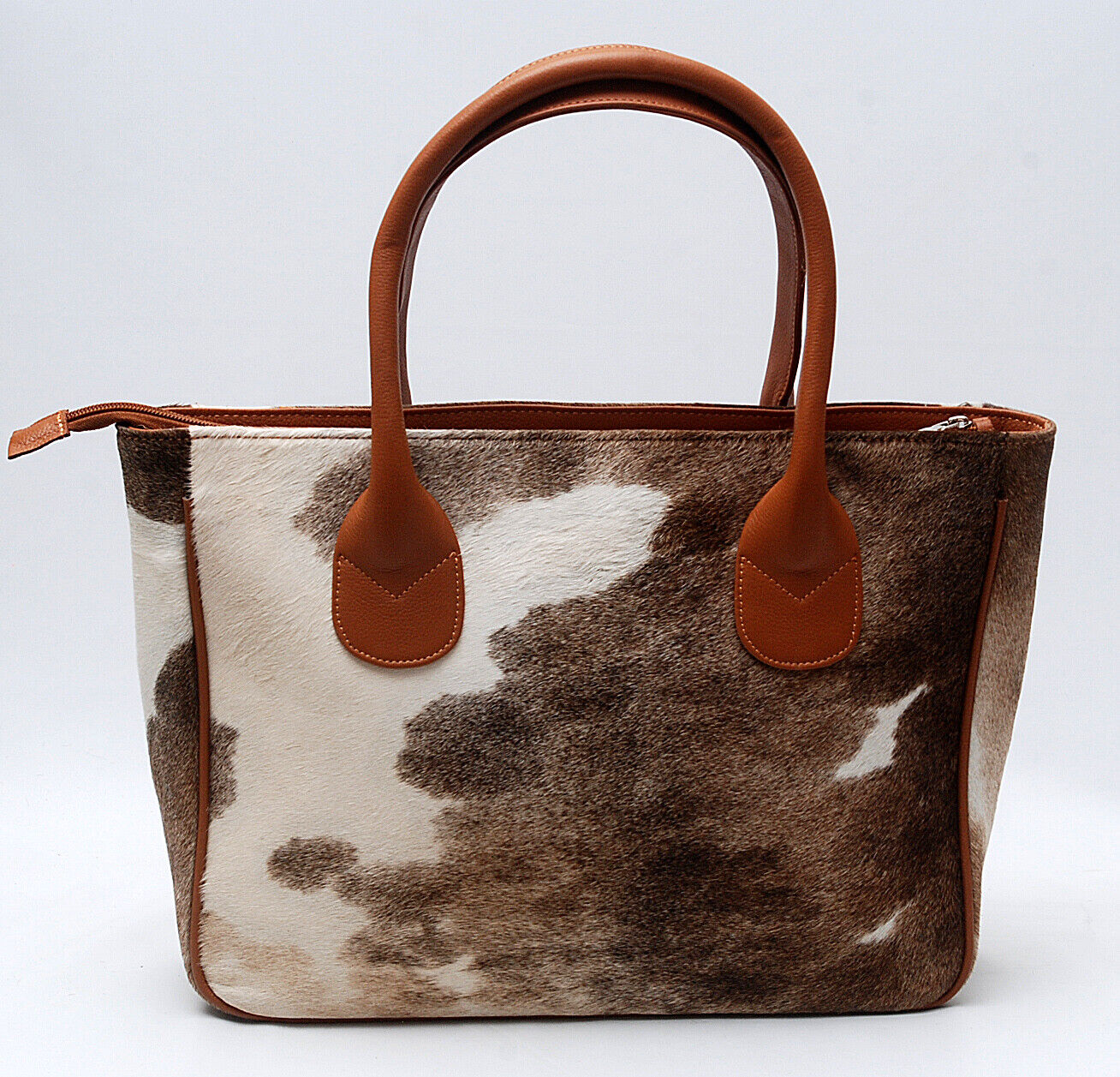 Uniquely textured and resilient cow skin tote purse built to last through daily commutes and spontaneous getaways alike. Its spacious interior fits all your essentials, making it an ideal choice for those who value functionality and timeless design.