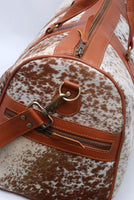 Saddle up for adventure with this cow skin duffle bag, designed to endure the rigors of travel in style.