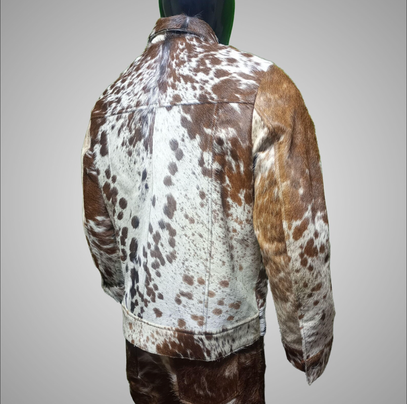 Men’s cowhide fur coat made from brown, white, and black cow print skin. Real hide jacket with a rugged look, designed for cowboy events and rustic menswear edits.

