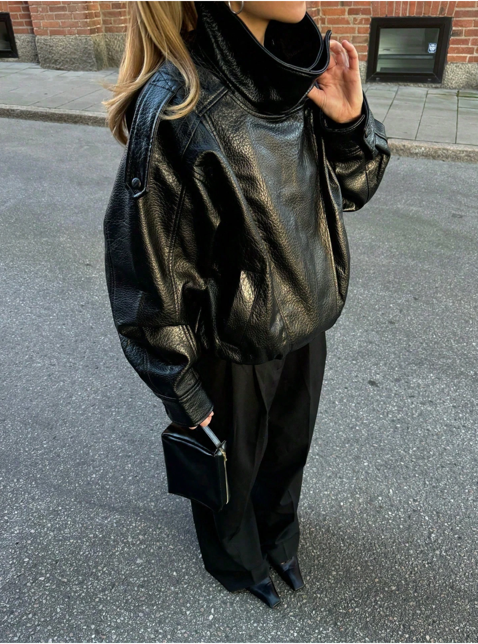 Oversized leather jacket women's casual style with functional pockets and relaxed dropped shoulders.