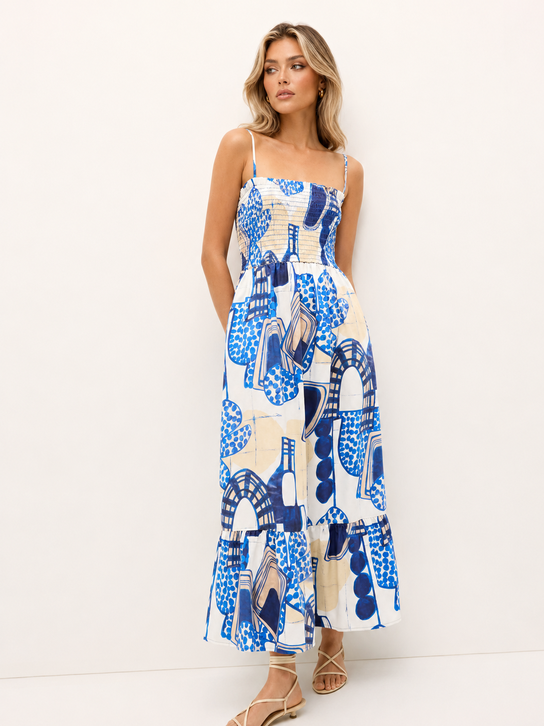 Blue vacation maxi dress featuring a fitted smocked bodice, side pockets, and an ankle-length tiered hem.