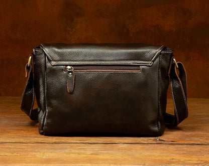 Brown leather crossbody satchel shown from the bottom with structured rectangular base and natural leather grain.