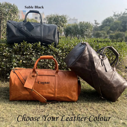 Brown leather weekender bag crafted from full grain cowhide with detachable padded strap and organized overnight travel storage.
