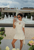 Cream knit mini dress with keyhole neck and ruffle hem