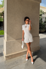 Cream knit mini dress with keyhole neck and ruffle hem