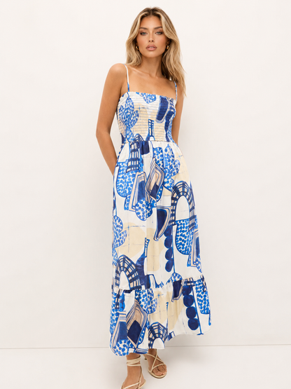 Blue and white abstract print maxi dress with a smocked bodice, slim straps, and a full flowing skirt.