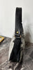 Cowhide bag styled as a shoulder handbag with soft gray hair-on hide, black accents, and curved silhouette.