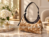 Cowhide shoulder bag with warm tan and white natural hide markings, black upper trim, and metal strap hardware.