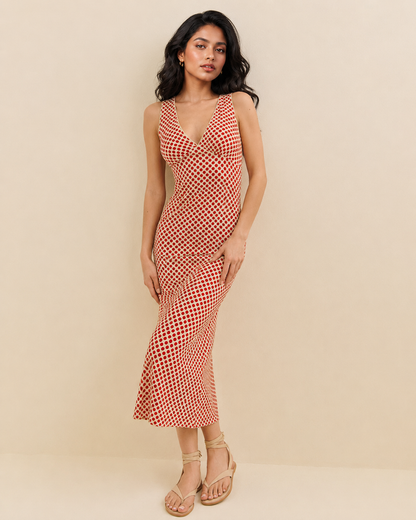 Cream and red polka dot midi dress with a sleeveless V-neck and softly flared lower skirt.