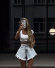 Denim shorts with blue wash, high waist, wide leg shape, pockets, and raw frayed hem.