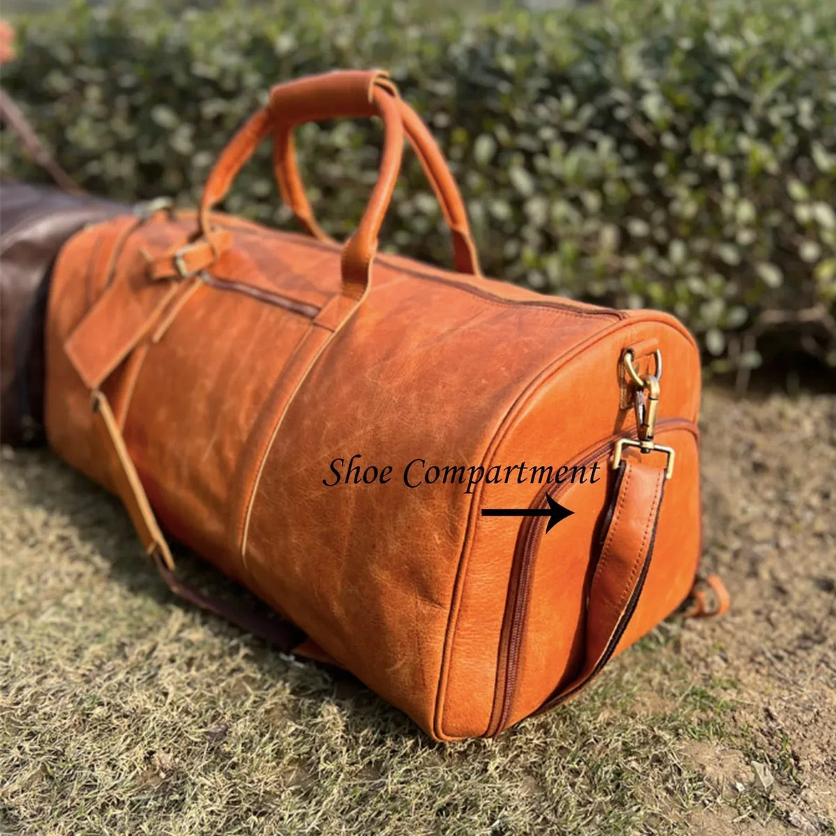 Genuine leather travel duffle bag with spacious main compartment, laptop pocket, shoe storage and reinforced leather carry handles.
