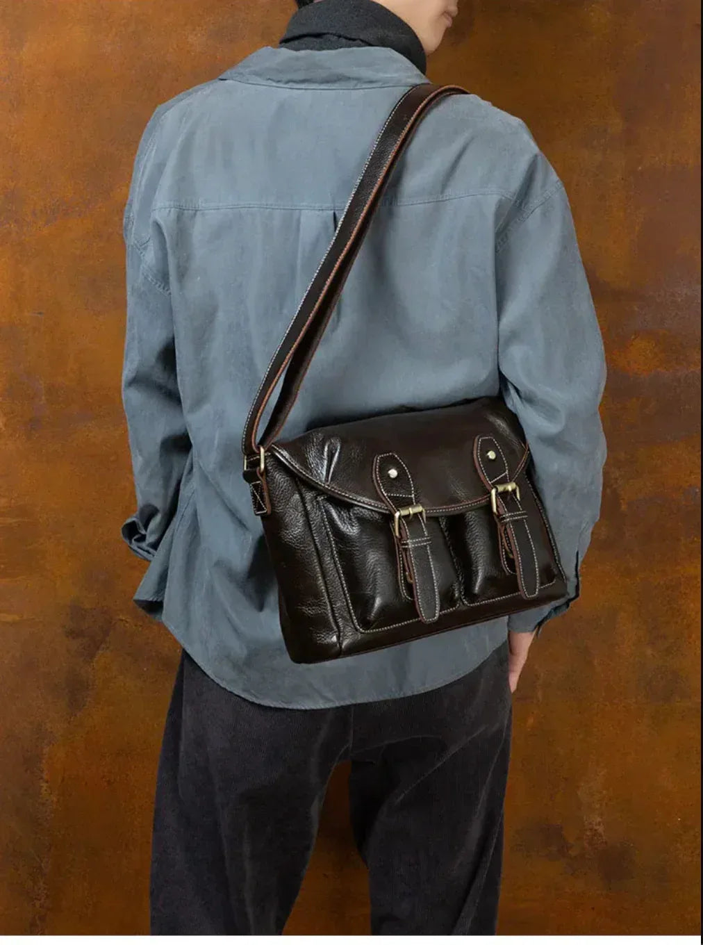 Leather crossbody bag for men worn over the shoulder with dark brown leather and organized front storage pockets.