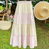 Maxi skirt with pink and yellow floral tiers and flowing A-line shape.