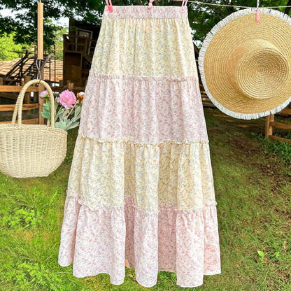 Maxi skirt with pink and yellow floral tiers and flowing A-line shape.