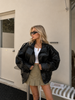 Black leather jacket women oversized silhouette with structured collar and button-front closure.