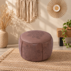 Round faux leather pouf ottoman featuring detailed paisley embossing, soft curved form, and neutral styling for boho rooms.
