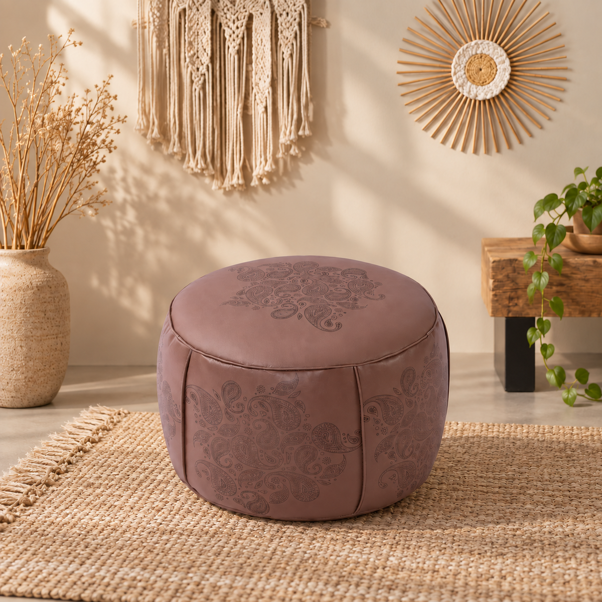 Round faux leather pouf ottoman featuring detailed paisley embossing, soft curved form, and neutral styling for boho rooms.