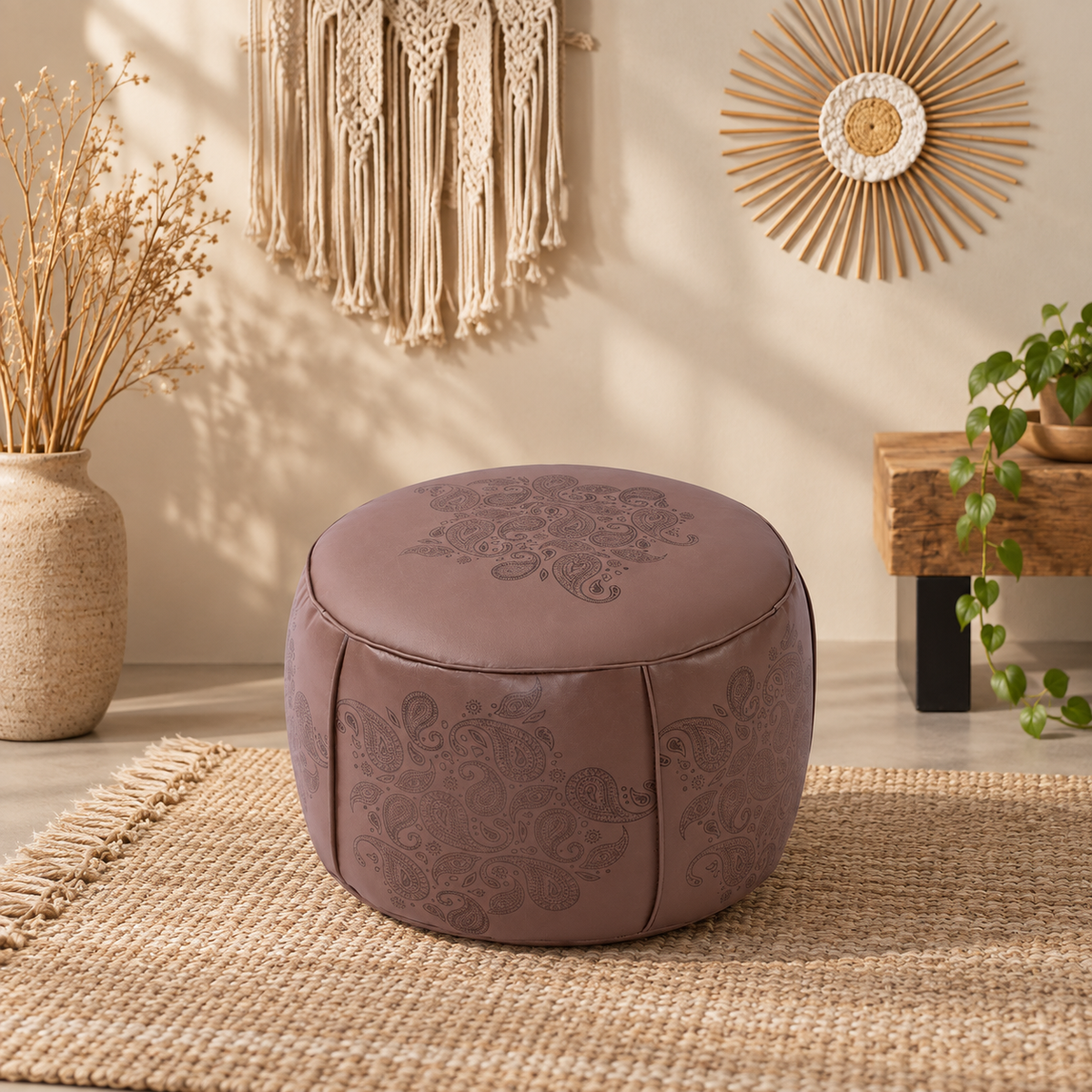 Round faux leather pouf ottoman featuring cream finish, coordinating embossed pattern, and soft rounded form for neutral interiors.