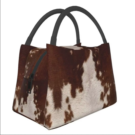 Elegant cowhide lunch bag with a unique pattern and sturdy handle, offering a stylish yet functional way to carry your meals. Perfect for work, picnics, or daily use.