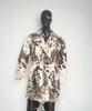 Women's brown and white cowhide trench coat made from real hair-on-hide leather with belted waist and tailored western silhouette.
