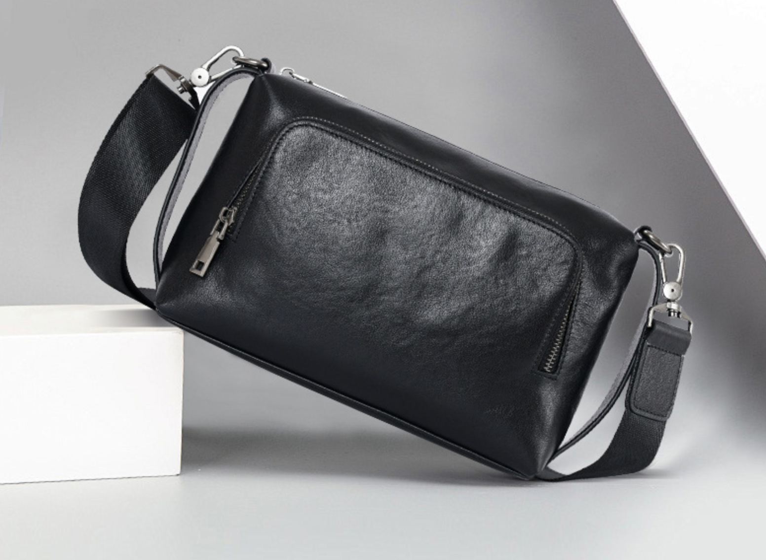 Schwarze Herren-Ledertasche zum Umhängen mit kompakter Form, Innenfächern und robustem Reißverschluss – perfekter Begleiter für unterwegs.

