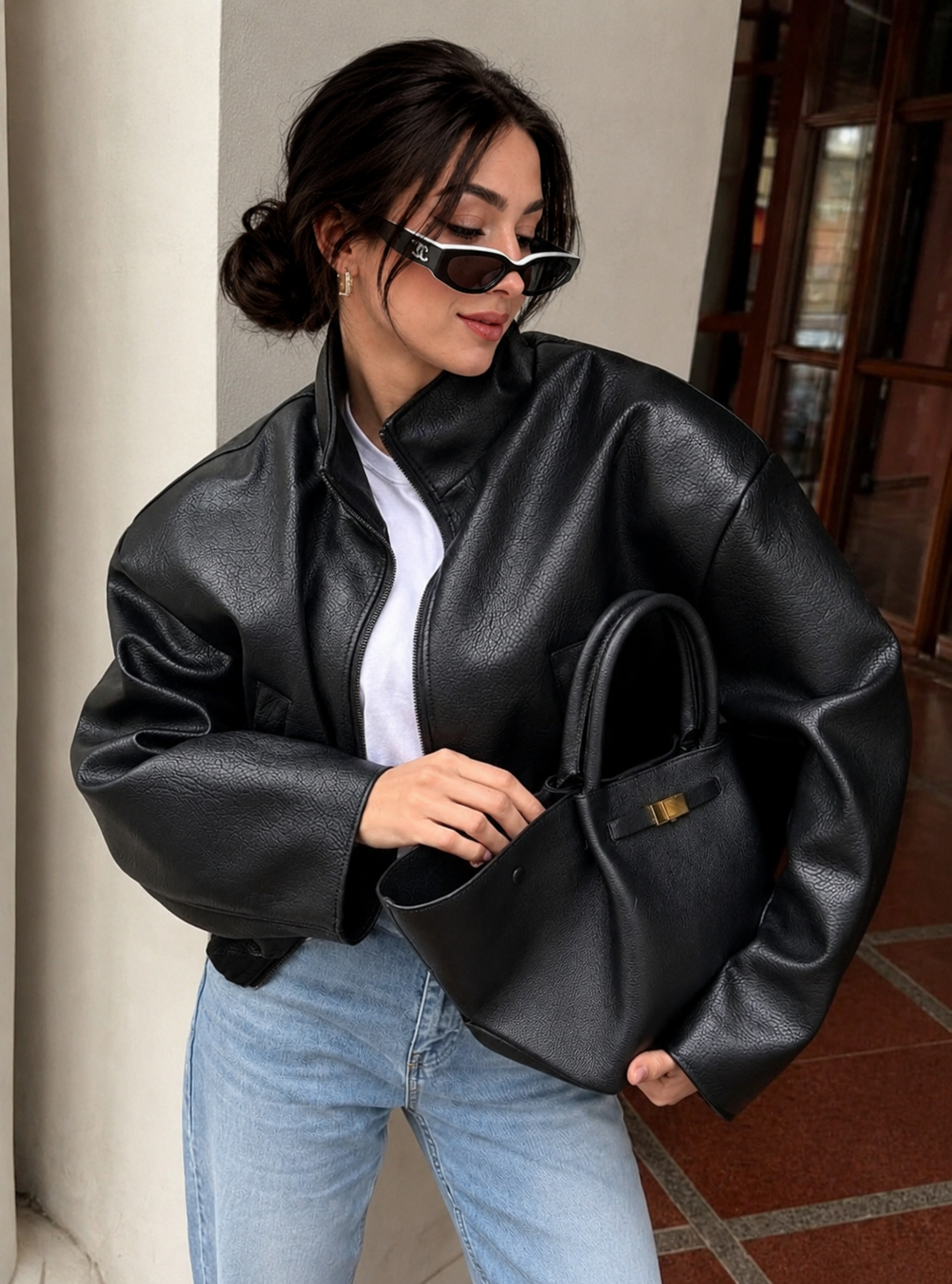 Women's cropped leather jacket featuring metallic hardware and full front zipper closure