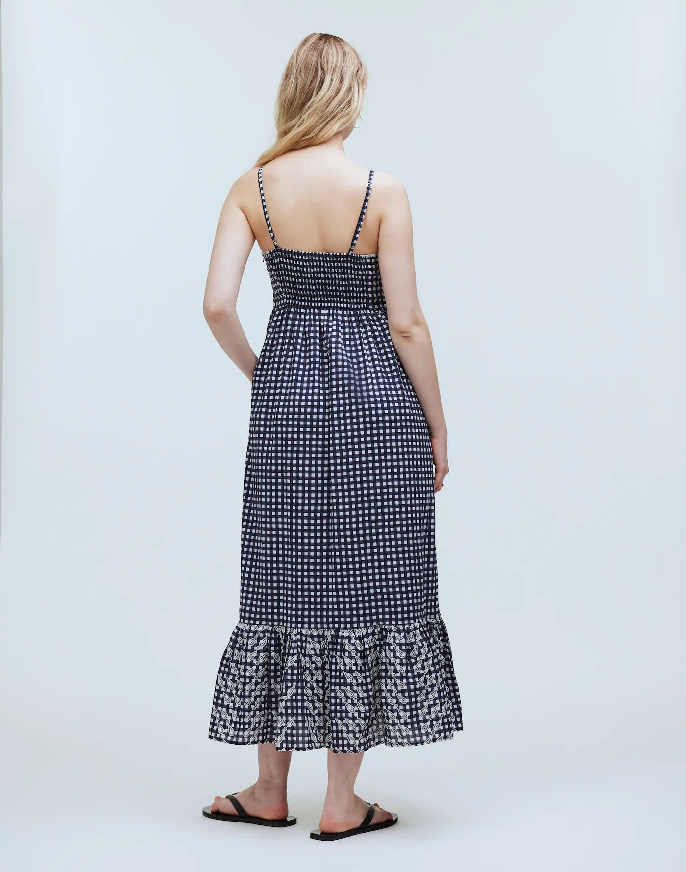 Dark grey long dress with a smocked back, narrow shoulder straps, and a softly gathered full-length skirt.
