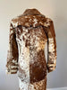Country western women’s cow skin coat in black, brown, and white. Natural fur trench coat perfect for rodeo fashion and outdoor events.