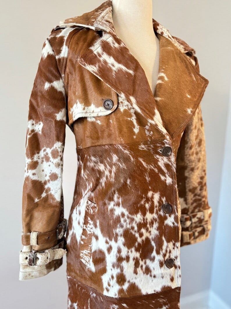 Genuine cowhide fur trench coat for women with ranch-inspired styling. Distinct natural hide patterns make each coat one of a kind.