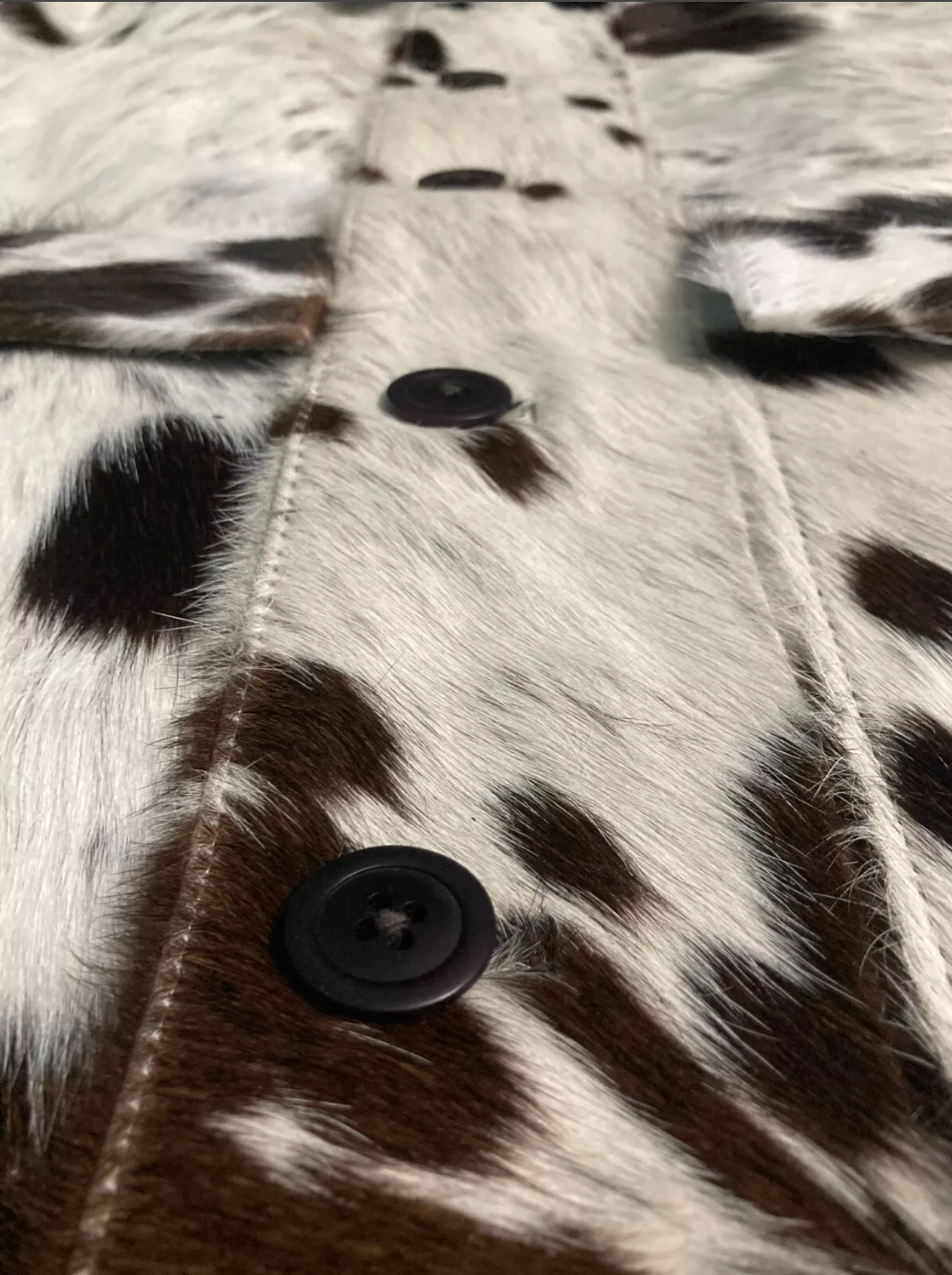 Authentic cow jacket crafted in tricolor cowhide with black, white, and brown patches. Unique cow print jacket for women who want Western fashion with real hide.

