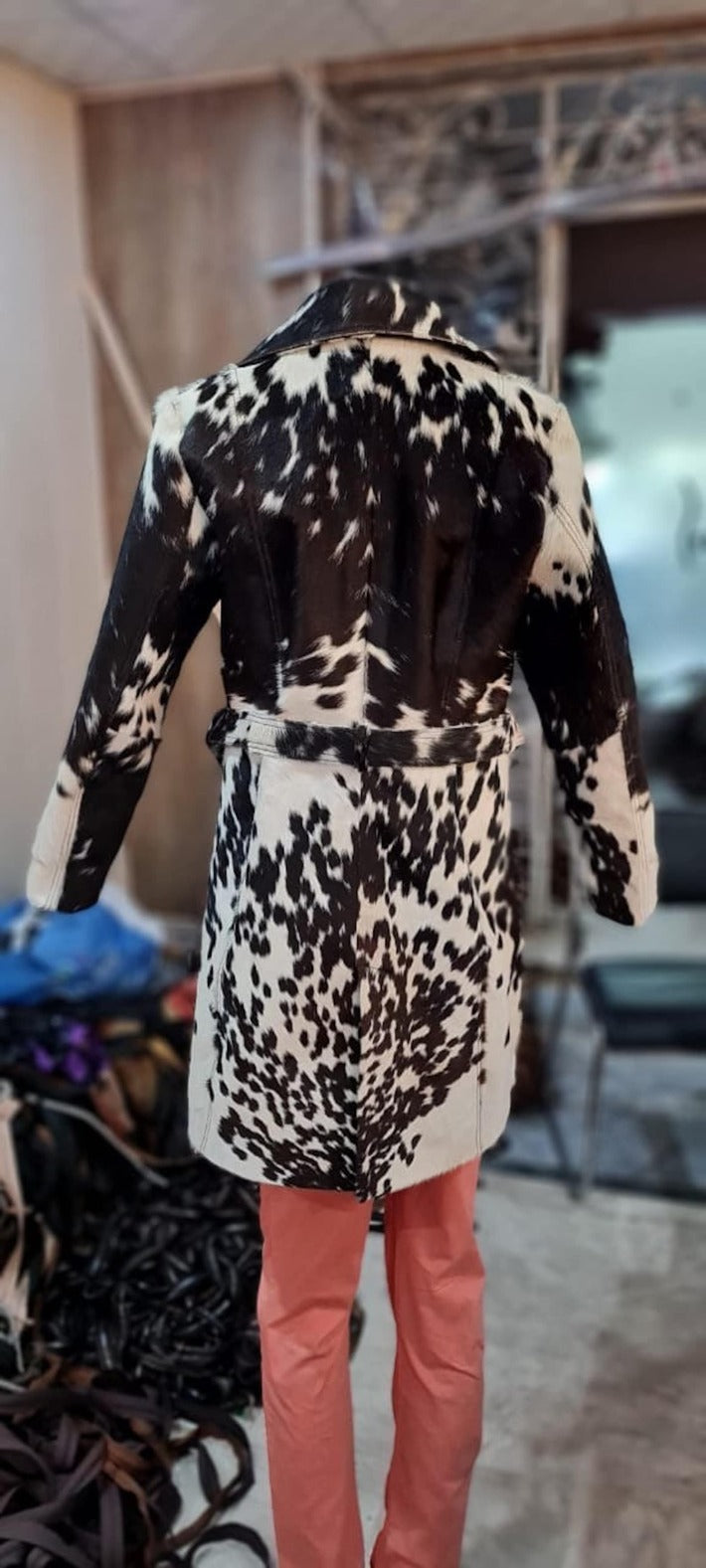 Make a statement with a cow jacket womens look—real cowhide leather, mid-thigh length, bold lapels, and a fitted waist belt.

