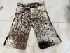 Tricolor cow skin shorts featuring black, brown, and white patterns. Each pair is unique, made from hair-on leather with a western-style cut.