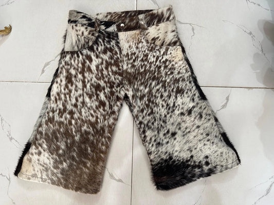 Tricolor cow skin shorts featuring black, brown, and white patterns. Each pair is unique, made from hair-on leather with a western-style cut.