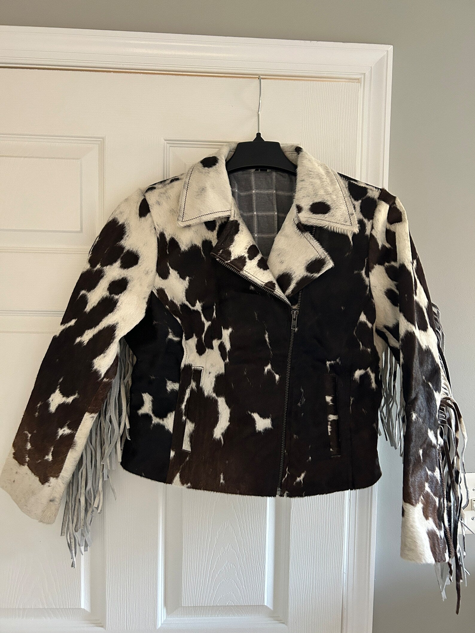 Stand out in a cowhide fringe jacket women's style—real cow hide jacket with fringe, bold cow print, and Western edge for rodeo, concerts, or casual wear.

