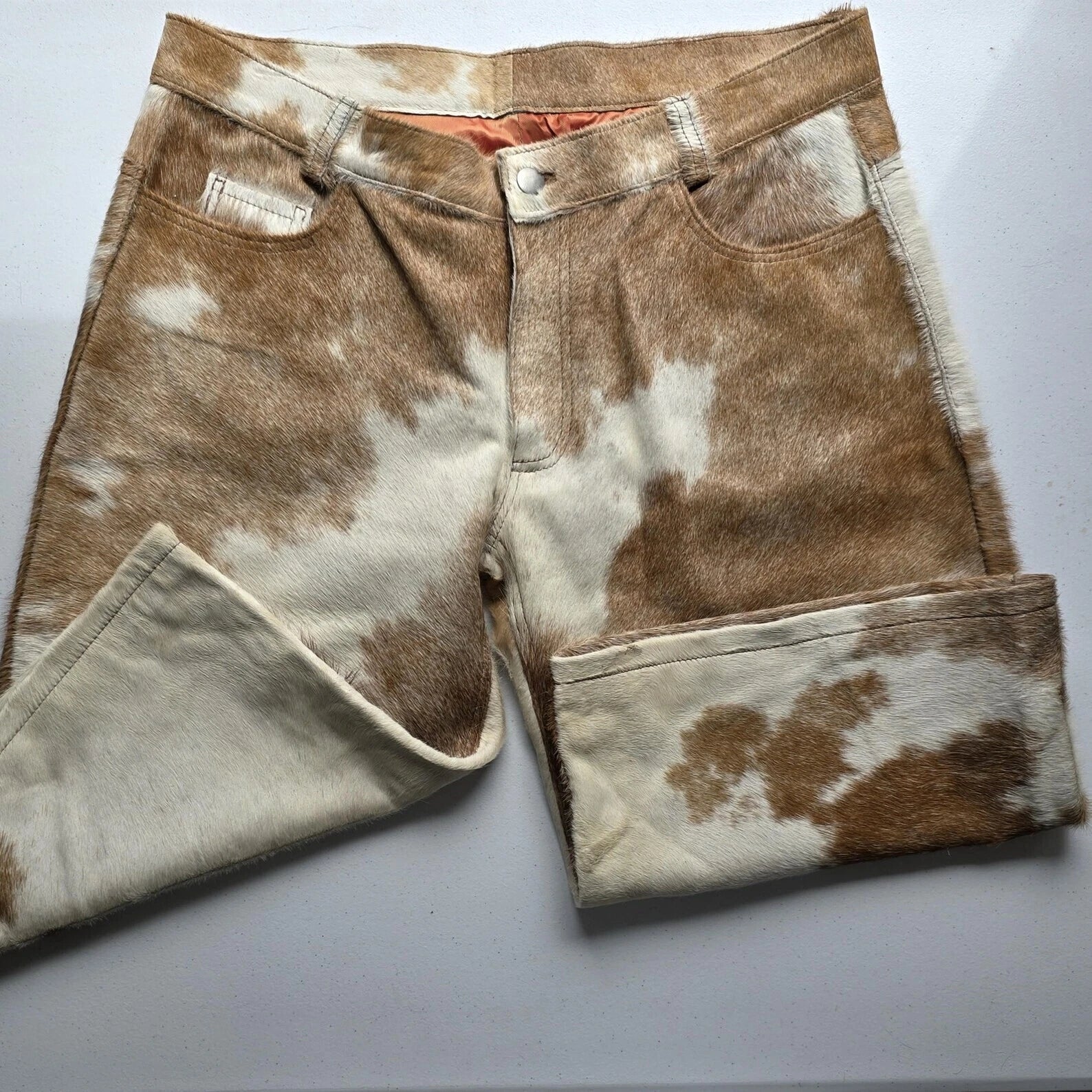 Add edge to your wardrobe with handcrafted cow skin men shorts, designed with one-of-a-kind cow fur patterns and classic five-pocket detailing.