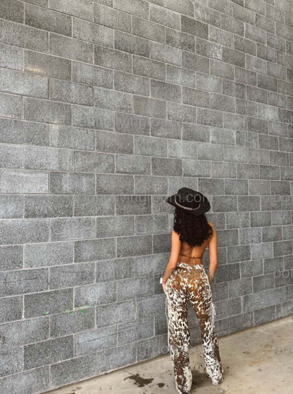 Stand out in brown white cowhide trousers with natural cow print pattern and flared cut. Ideal for western themes, southern fashion, and statement cowgirl pants styling.

