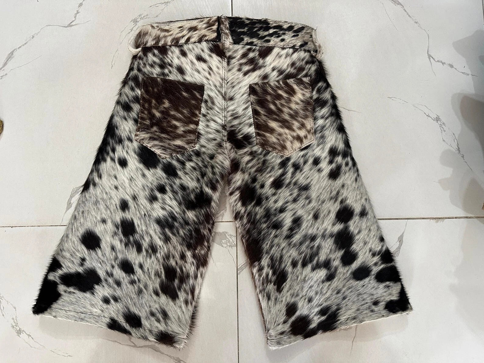 Genuine cowhide shorts for men with natural markings. Mid-rise fit, five pockets, and strong visual texture in a one-of-a-kind leather blend.
