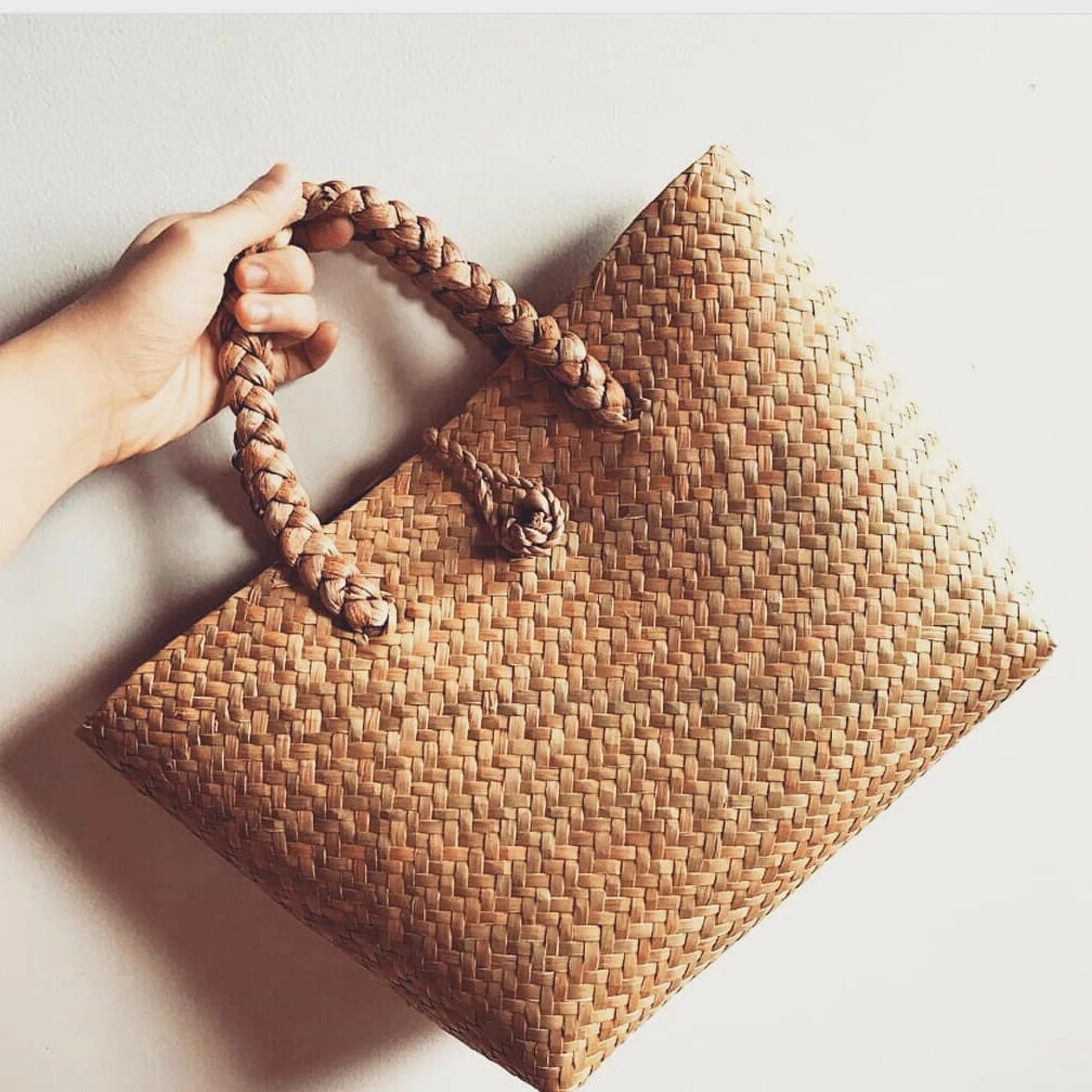Seagrass rattan tote bag with loop closure and structured base. A must-have rattan purse for beach lovers and natural fiber fans.
