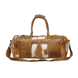 Roomy, brown & white cowhide duffel: perfect for long journeys! carry tons, with pockets to spare. real leather, built to last.