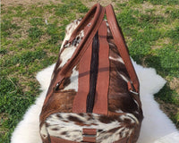 Travel in timeless style with this cowhide travel bag, a blend of sophistication and practicality.