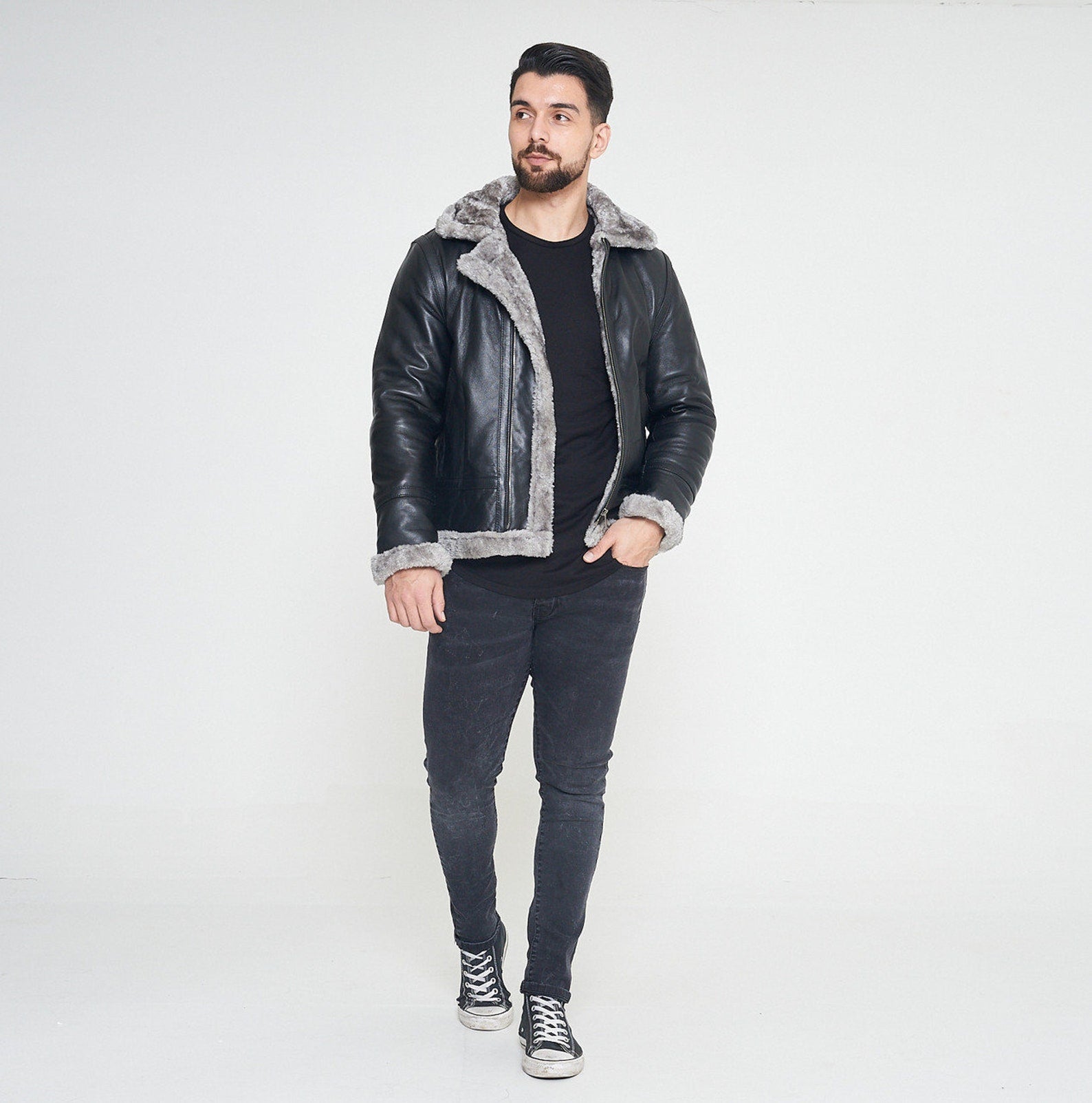 Stylish leather jacket with fur accents on the collar and cuffs, displayed against a wintery backdrop.