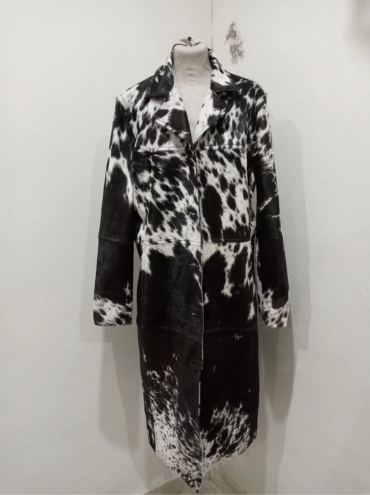 Make a statement with this genuine cow fur trench coat featuring black and white cowhide panels. A long cowhide jacket perfect for rodeo, ranch looks, and cowboy-inspired fashion.

