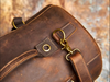 Modern leather duffle backpack with a minimalist design, adjustable straps, and secure zipper closures, placed on a desk.