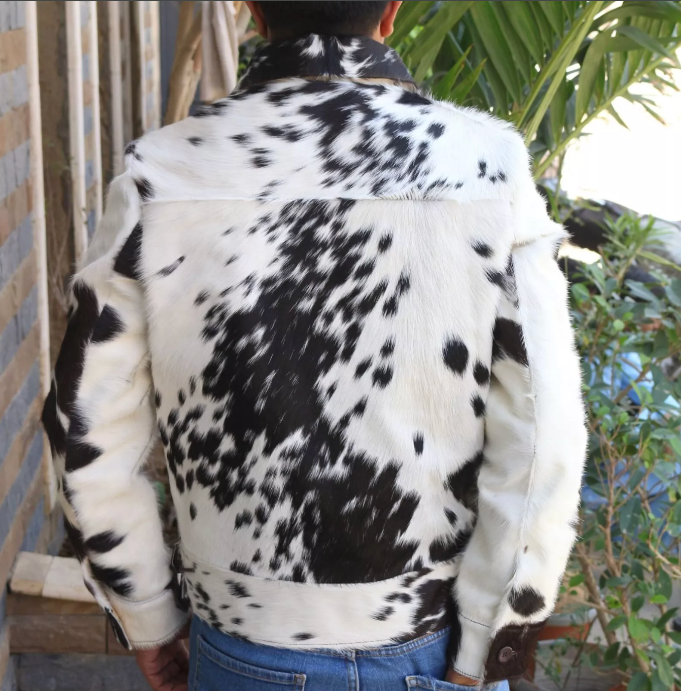 Cowhide coat made from real black and white hair-on-hide. Mens cowhide jacket design includes pockets, button cuffs, and Western-inspired details.


