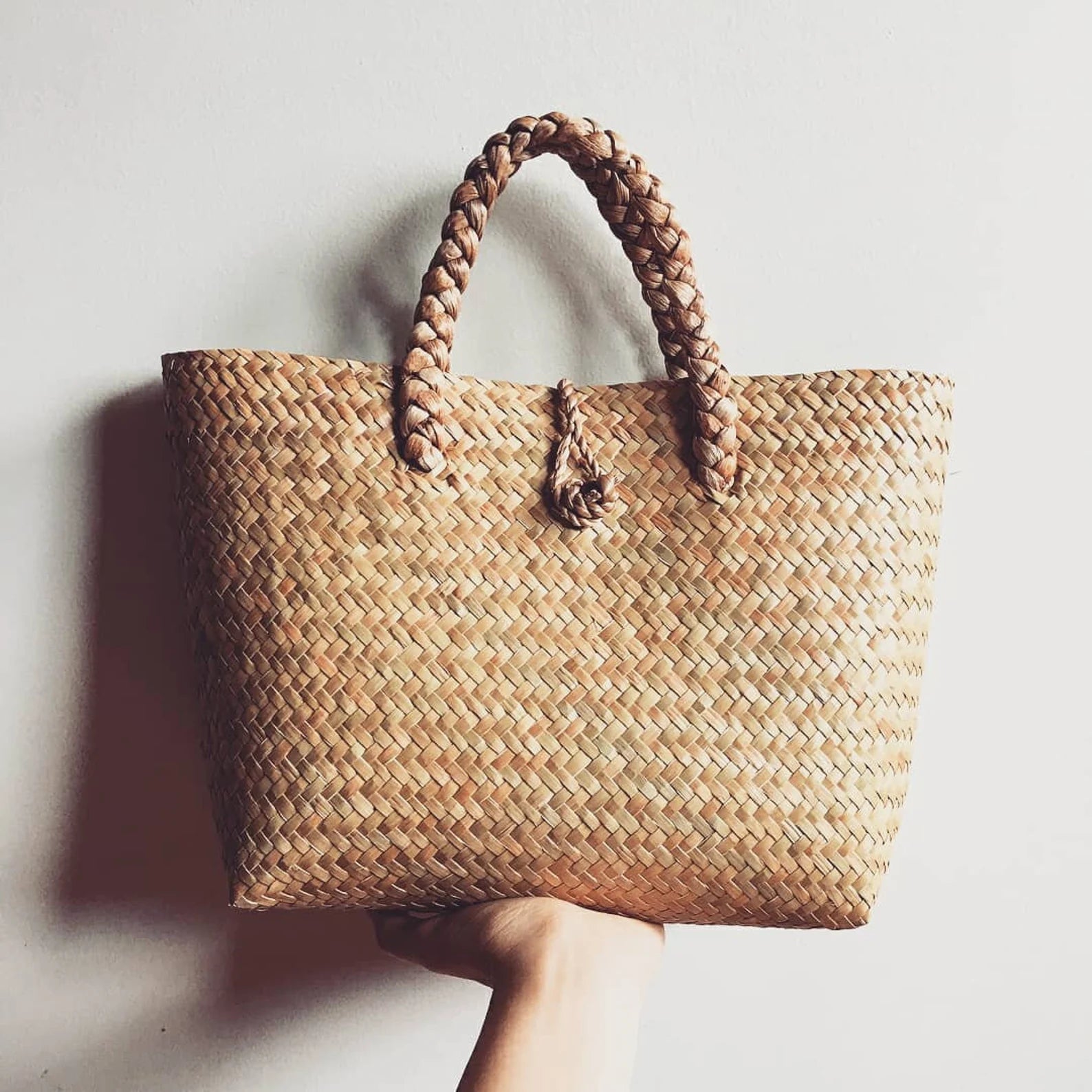 Handwoven seagrass rattan bag with natural braided handles. A unique summer bag perfect for beach days, markets, and casual outings.