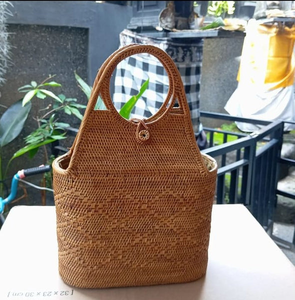 Elegant rattan shoulder bag paired with a casual outfit at a cafe.